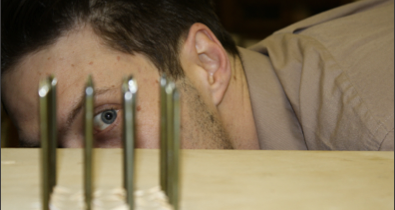 Physics teacher, Green, hits nail on head; builds bed of nails for class demonstration