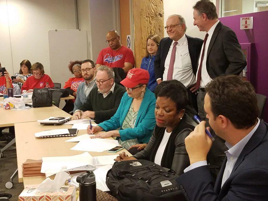 Karen Lewis, President of the Chicago Teachers Union, and Joseph Moriarty, Chief Labor Relations Officer for CPS, sign the tentative agreement.
