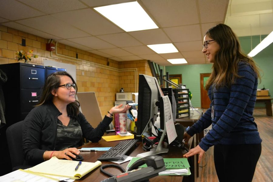 Ms. Escobar helps Senior Brianna Santiago, Div 771, in the attendance office during fifth period. 
