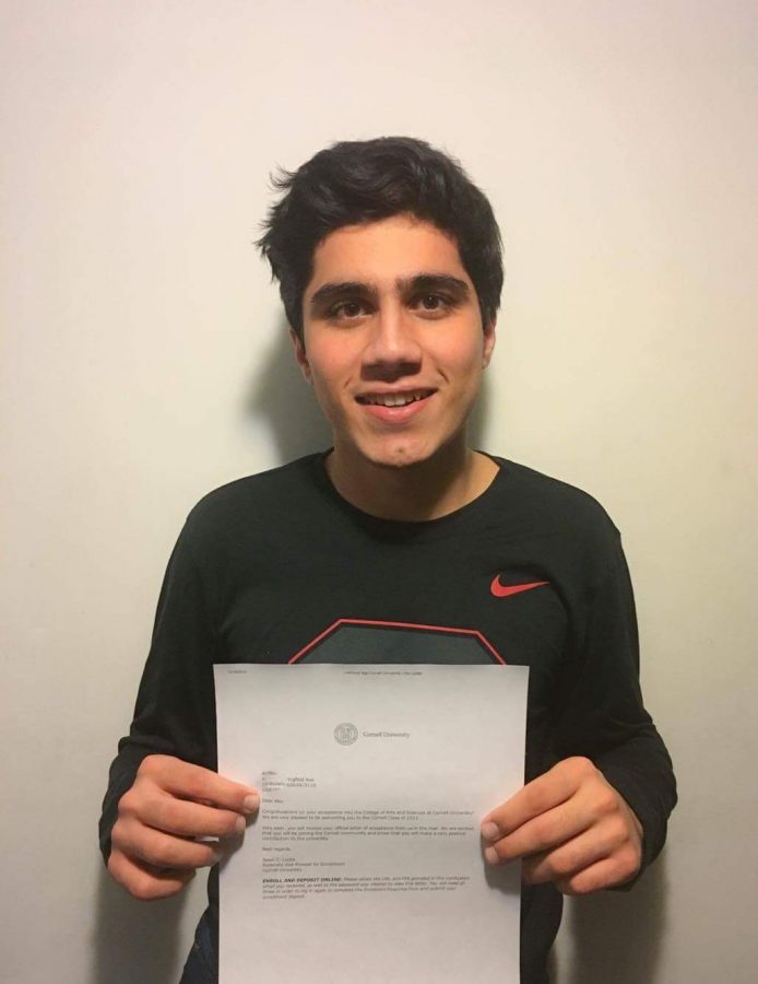 Qader poses with his acceptance letter to Cornell University, where he received a full-tuition Posse scholarship.