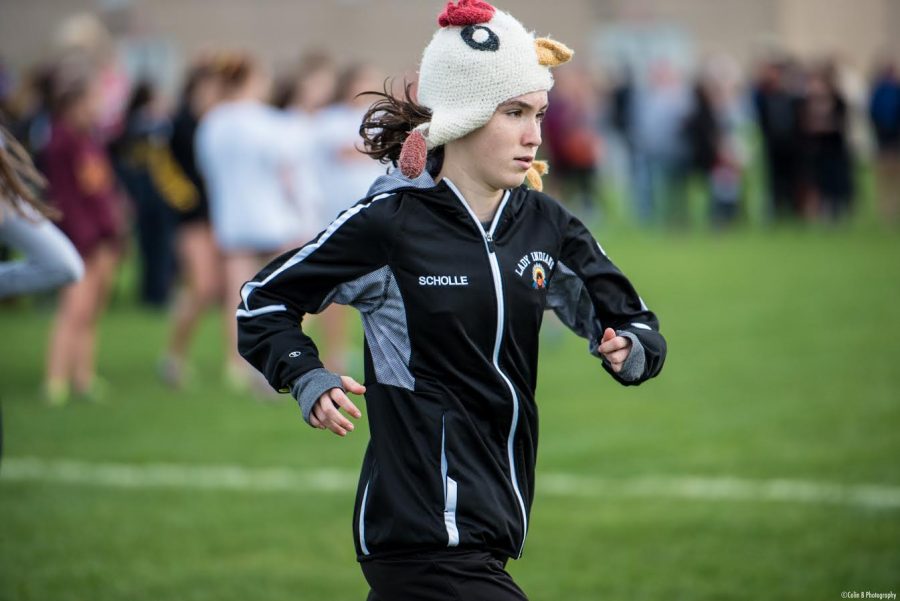 Scholle warms up in her lucky chicken hat before a regional race at Niles West High School.