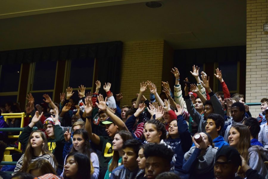 Fans raise their arms in anticipation of a free throw during the Girls Basketball home game against Linclon Park 