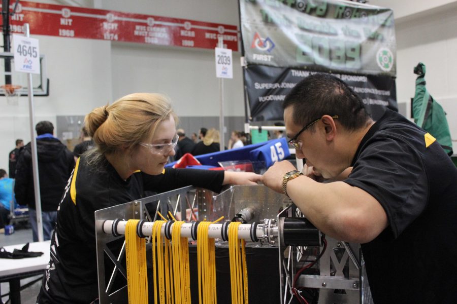 Emily Gost and Coach Law work on a robot during the Central Illinois Regionals.