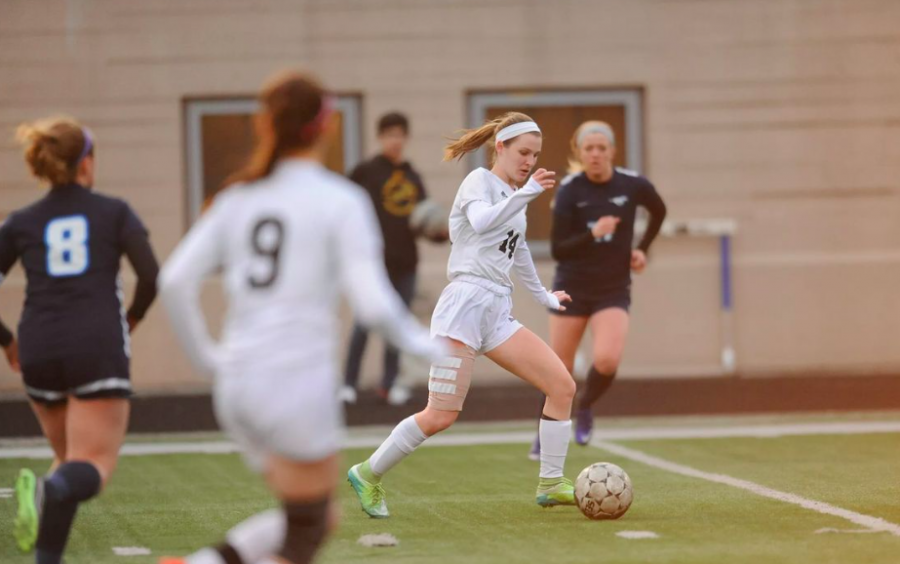 Midfielder Carlye Makuch (14) dribbles the ball up the field as Cam Niforos (9) looks on in the team’s home game against Downers Grove South. Lane tied DGS to move to 0-1-2. (Photo Courtesy of Patrick Gorski)