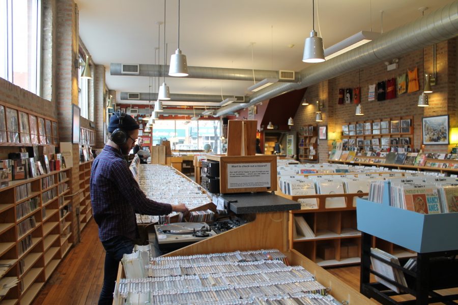 An employee at Dusty Groove places a record onto the in-store turntable. 