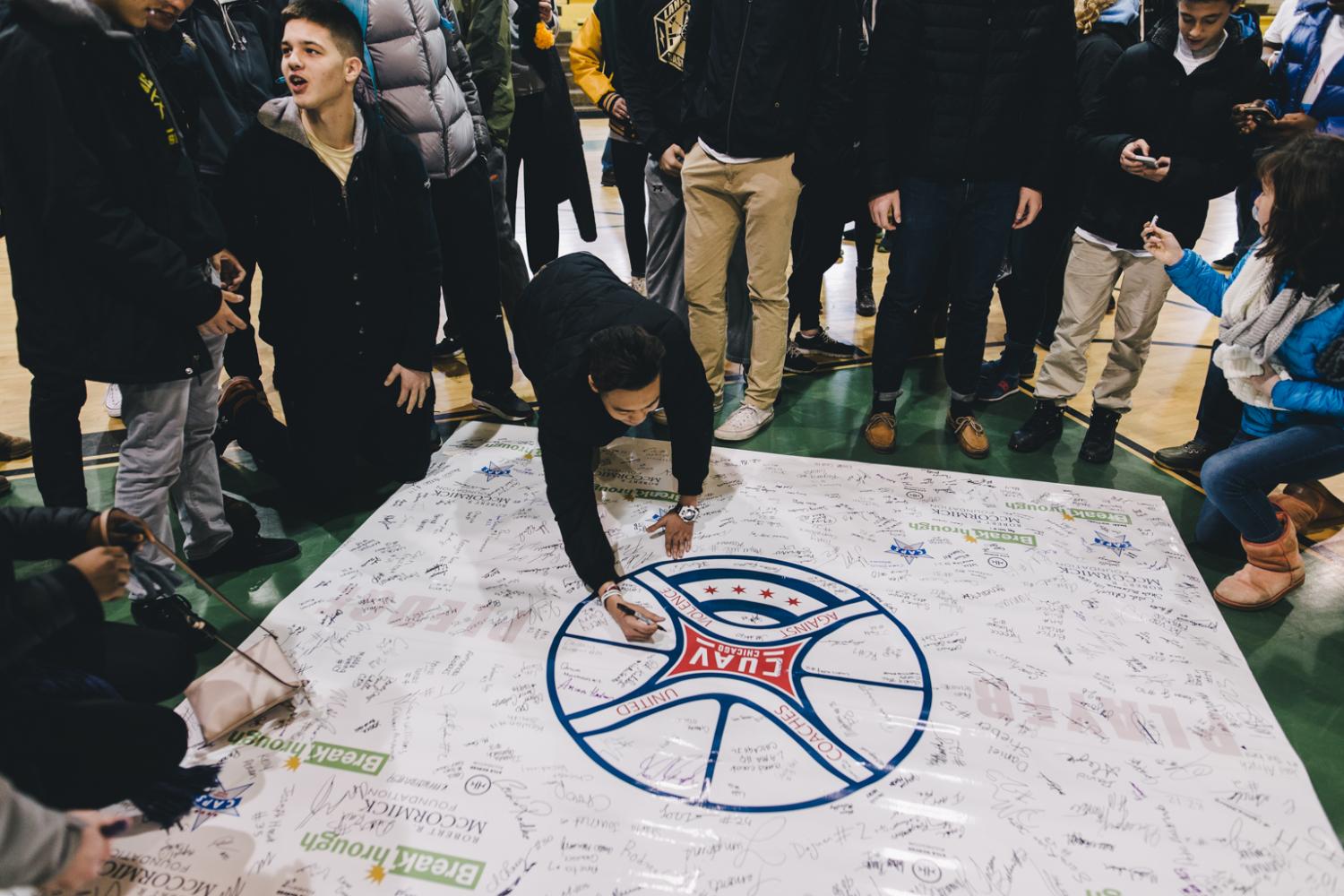Zhaoyao Li, Div 759, signs the Coaches United Against Violence poster at this year’s rally.