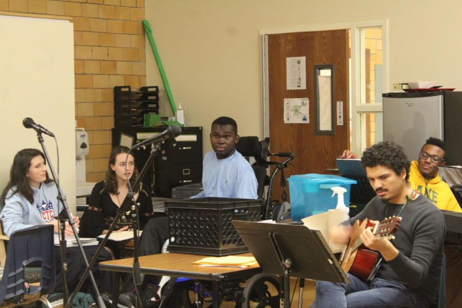 Mr. Payano plays the guitar, a student leads in singing and the rest of the class performs as backup singers during Lanes music therapy class.