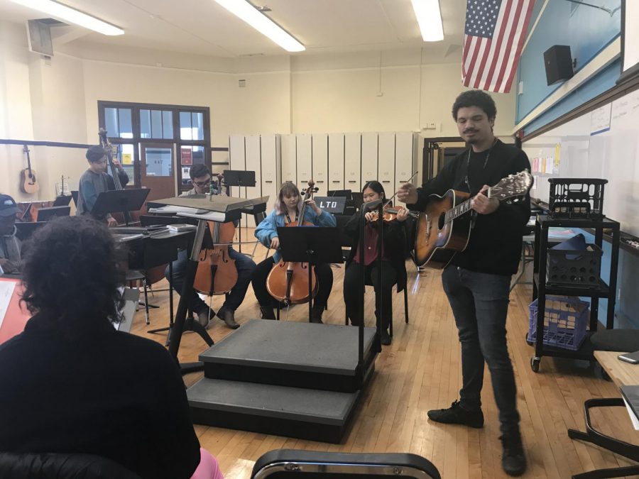 Unity Club members and sponsor Mr. Payano gather around to play the song Three Little Birds, by Bob Marley. The club meets every Wednesday in the Orchestra room to spread peace and positivity through music. Unity Club will be accepting donations until May for their instrument drive.