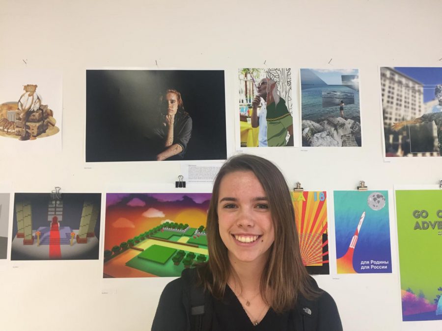 Abby Pinderski, Div. 967, is standing in front of her work, the three on the top row, which is currently displayed in the art room.
