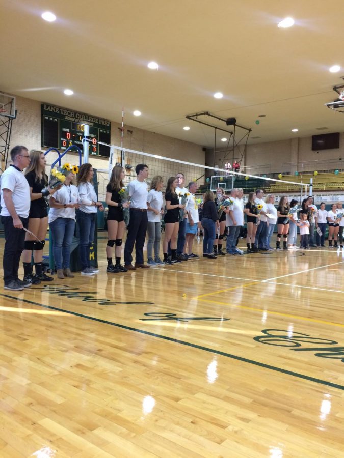 Varsity volleyball seniors line up with their parents. 