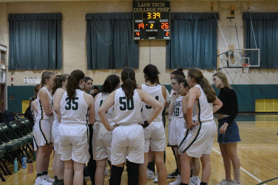 The girls huddle up during a timeout while trailing Marhsall by seven points.