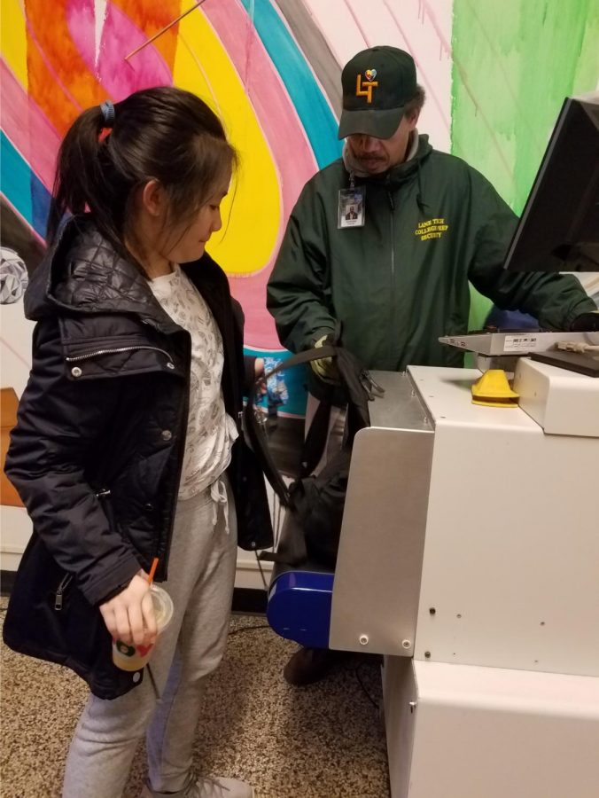 A student gets her bag checked by security as she enters the building.
