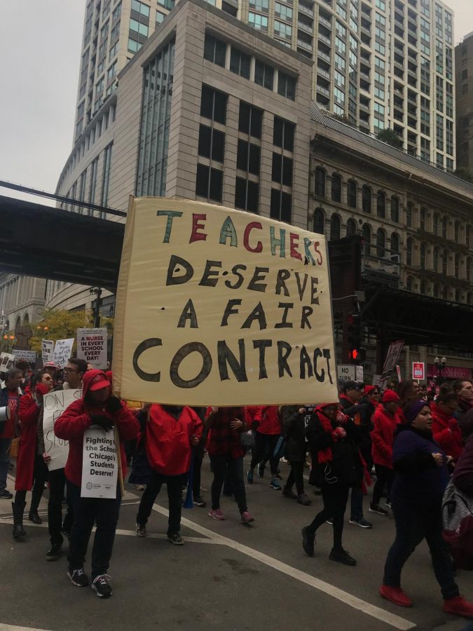 Union members hold sign reading Teachers deserve a fair contract during Oct. 25s march from Buckingham Fountain to City Hall.