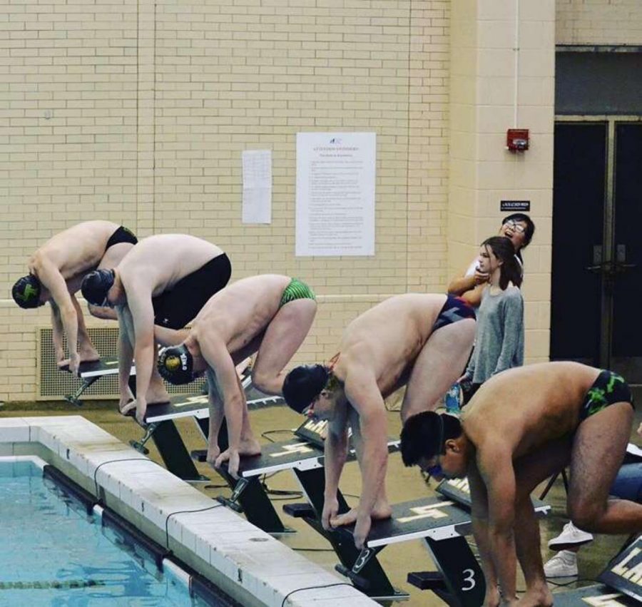 Boys of Lane Tech’s Swimming and Diving Team line-up to start a match against Taft.
