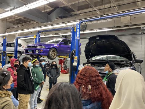  A tour guide shows students one of the automotive technology classrooms at Truman College
