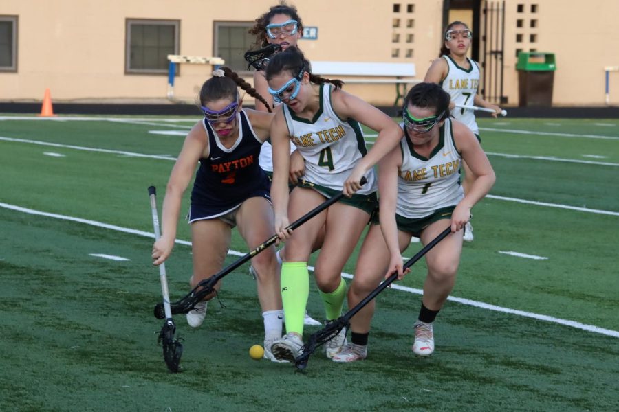 Lane’s Isabella Buonauro (#4) and Eliza McHale (#1) clash with Payton for a ground ball.
