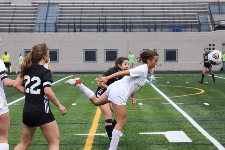 Lanes Gabriella Mann and a St. Ignatius defender attempting to hit the ball.