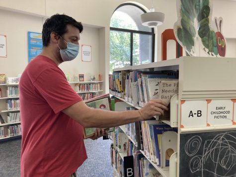 Sulzer Regional Library childrens associate librarian Joseph Burton reshelves books.
