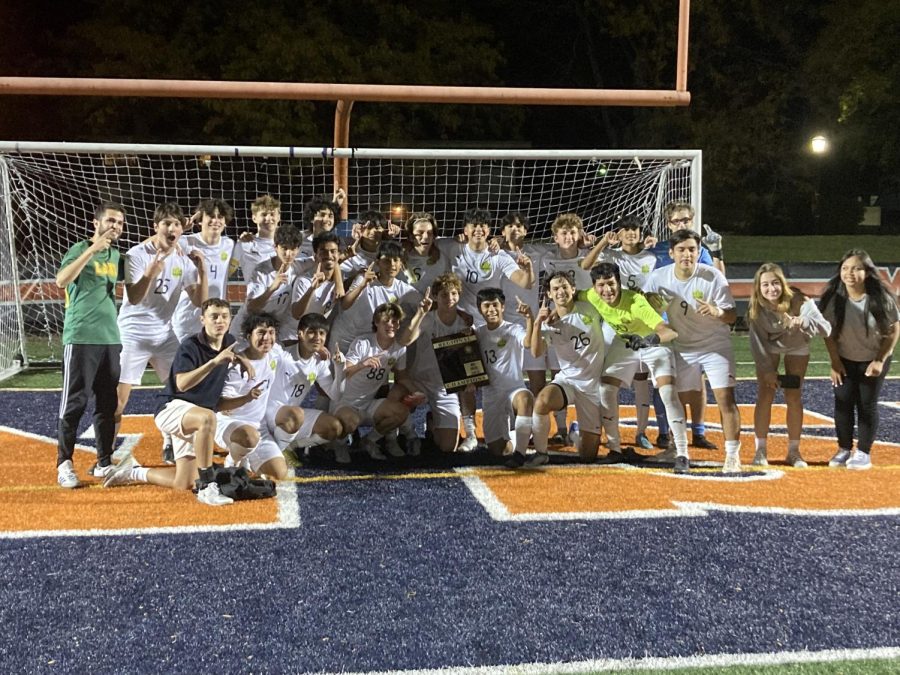 Boys Soccer poses with their championship plaque after winning regionals.