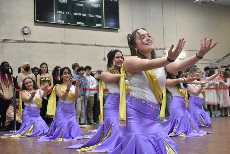 Senior Julia Harlan, front, and Cambodian Thai Club make a gesture during their performance.