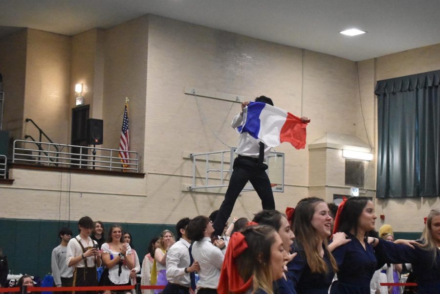 French Club lifts a member into the air to display the French flag.