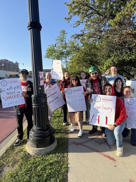 Lane Tech teachers outside of the building with their signs for the walk-in. 
