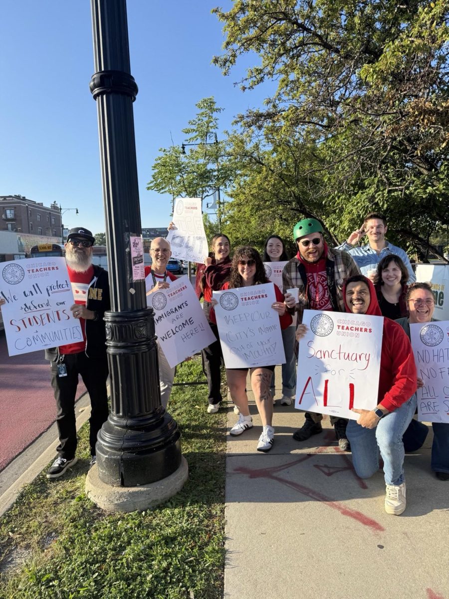Lane Tech teachers outside of the building with their signs for the walk-in. 
