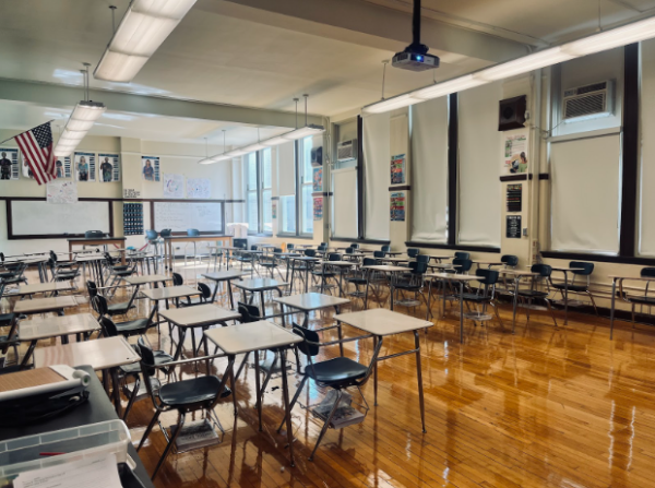 Empty classroom with an American flag on display in the distance.