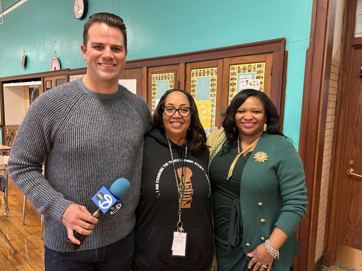 April Coleman, center, photographed with ABC7 reporter Rob Hughes and Principal Thompson. Five students in Black Rev. Literature created a presentation on the life of Jesse Jackson that was featured on the news following his death. Students are taking the opportunity to research his life and learn about activism. The presentation will also be part of the Black History Month Assembly Friday, Feb. 27. (Photo courtesy of Ms. Coleman)