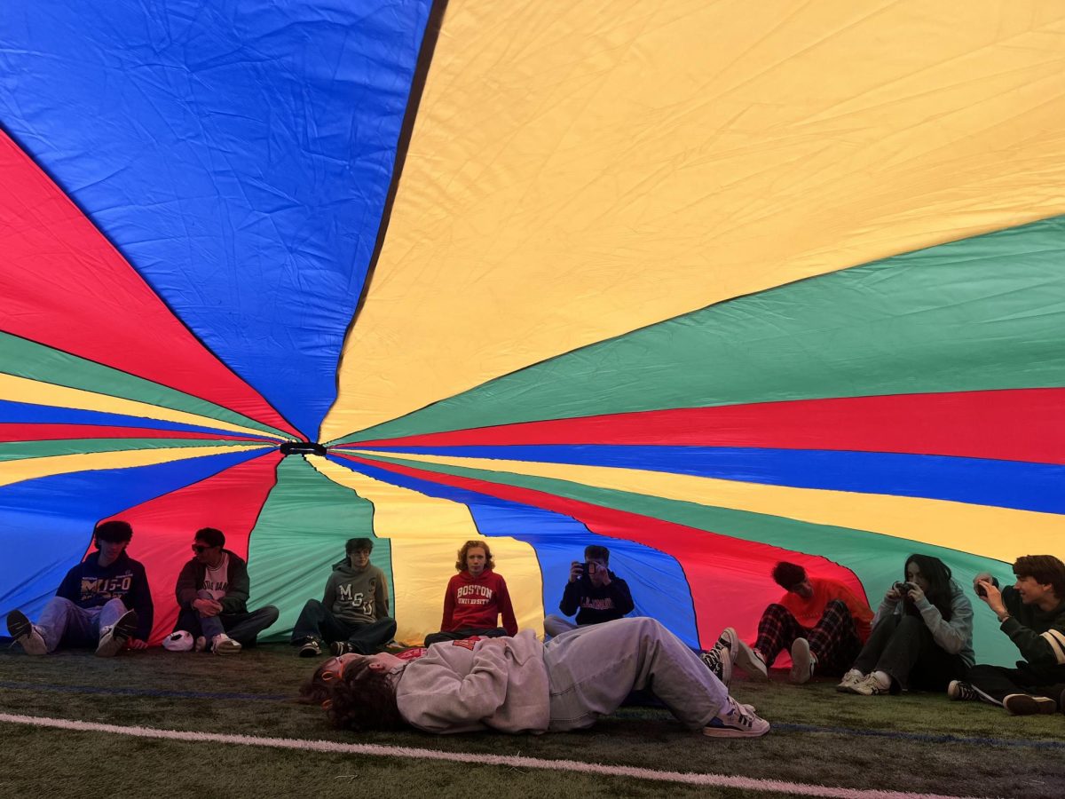 Seniors Sam Damiani, Diego Patino, Ben Lebeau, Isaac Dunn, Zach Buchar, Sam Liebert,
Hana Eichler and Andy Lawrence sit on the outer edge of a parachute with Asa Troccoli and
Lucy Arnold at the center.