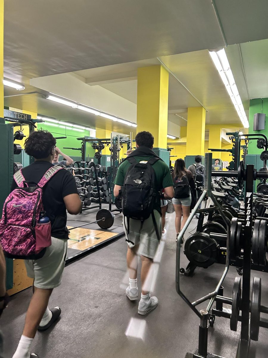 Lane Tech weight room filled with athletes from football and wrestling after school during spring sports season. 